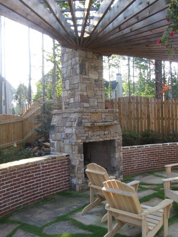 Custom fireplace with pergola and brick half wall