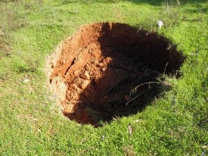 Sinkhole in grassy lawn