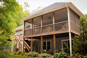 Back of large home with second story screened-in porch